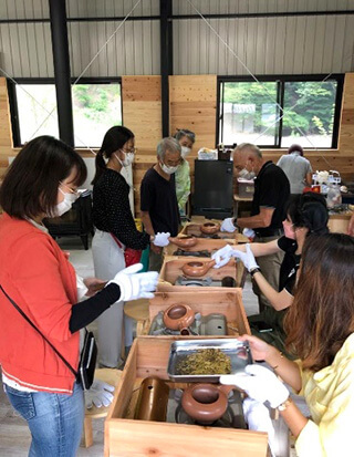 写真7.梅ヶ島のガストロノミーティーツアーを視察した本プロジェクトのお茶農家訪問の一コマ。ほうじ茶を焙煎する留学生たち。