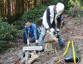 DIY作業で必要な木を切る岡田清隆さん（右）